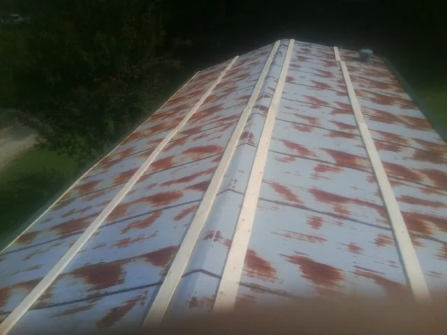 Rusted metal roof panels with new wood purlins before replacement — Storm Damage Roof Repair in Broadalbin by Roofing Brothers