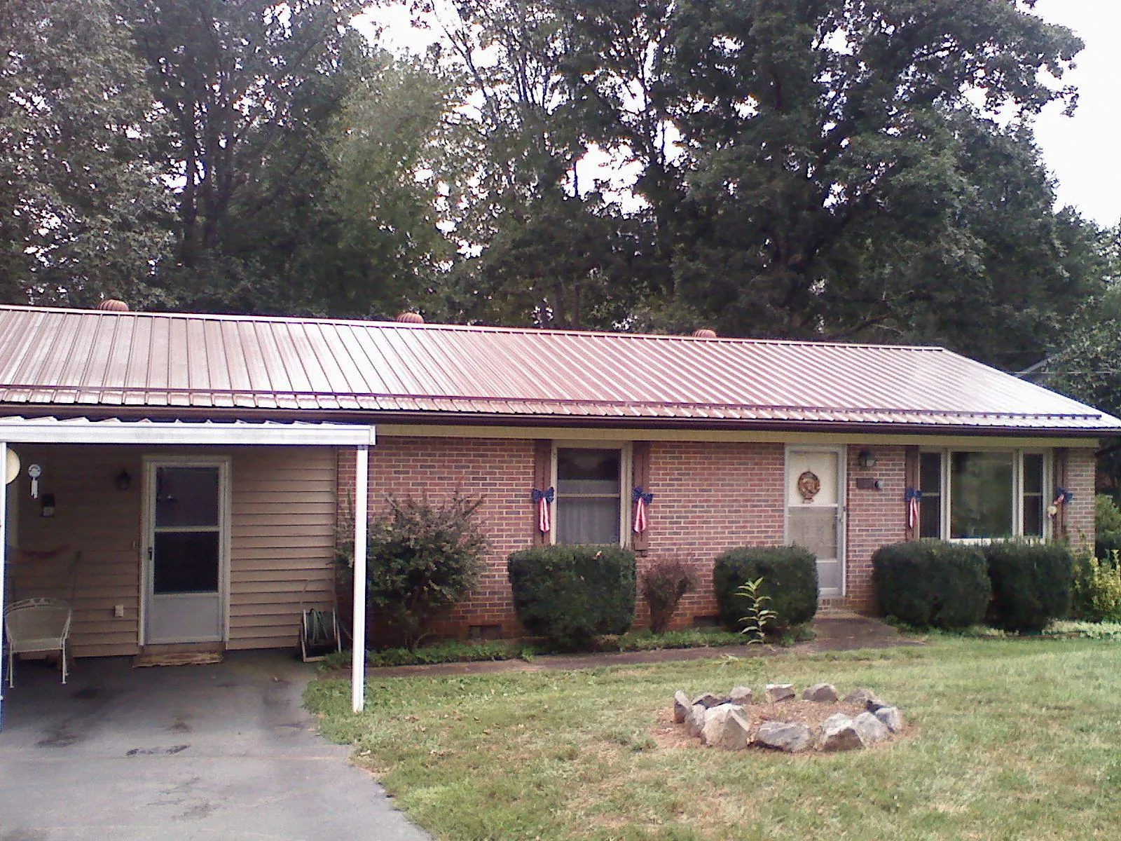 Bronze metal roof and carport on a brick ranch home — Roof Repair work by our crew in Broadalbin